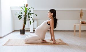 Pregnant woman practicing gentle prenatal yoga in a pleasant indoor setting