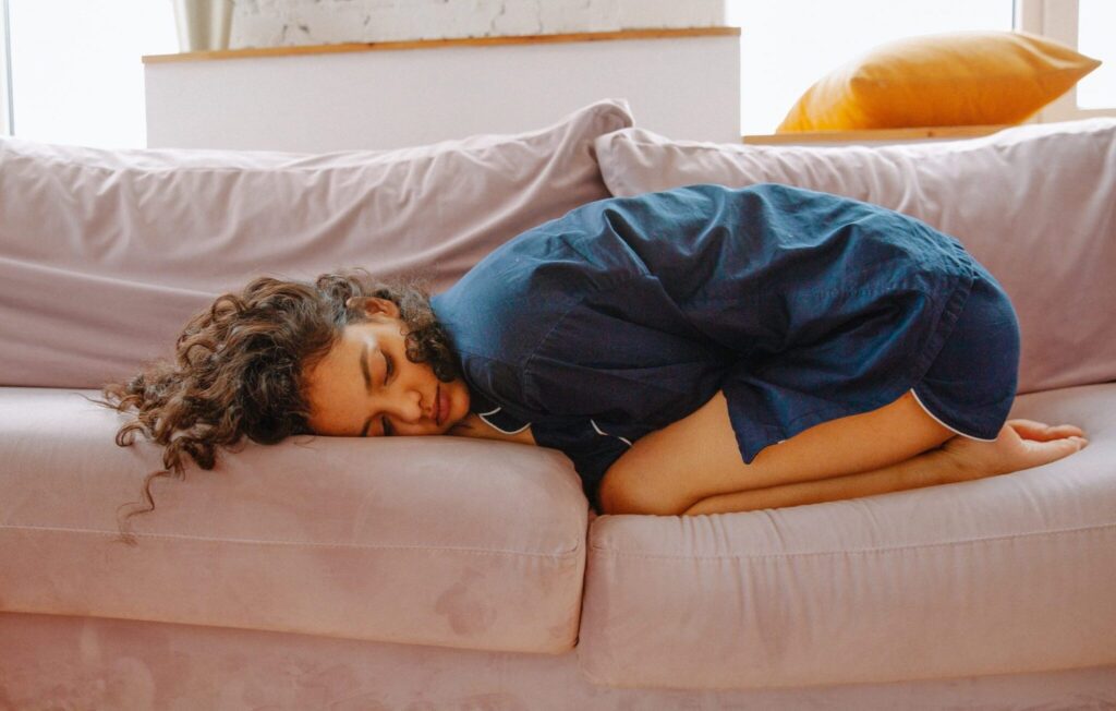 Woman in a gentle seated yoga pose with a calm expression, practicing during her menstrual cycle
