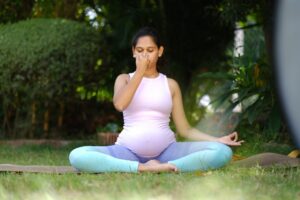 Pregnant woman doing yoga and pranayama to ease pregnancy discomfort