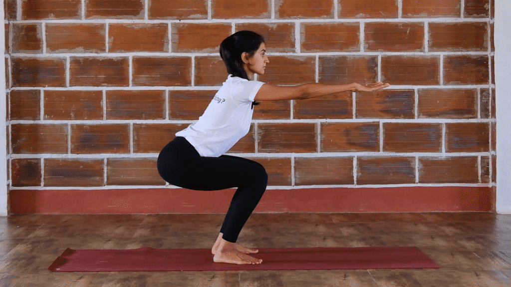 a women doing squatting knee movement which is a part of international yoga day sequence in mysore