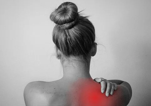 common yoga injuries or pain in shoulders, neck, back etc, a women holding her back shoulder, pain is indicated in red